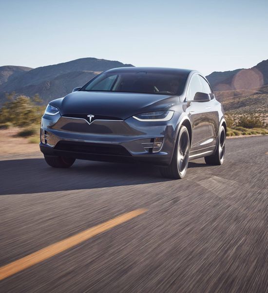Grey Tesla Model X front driving in desert 